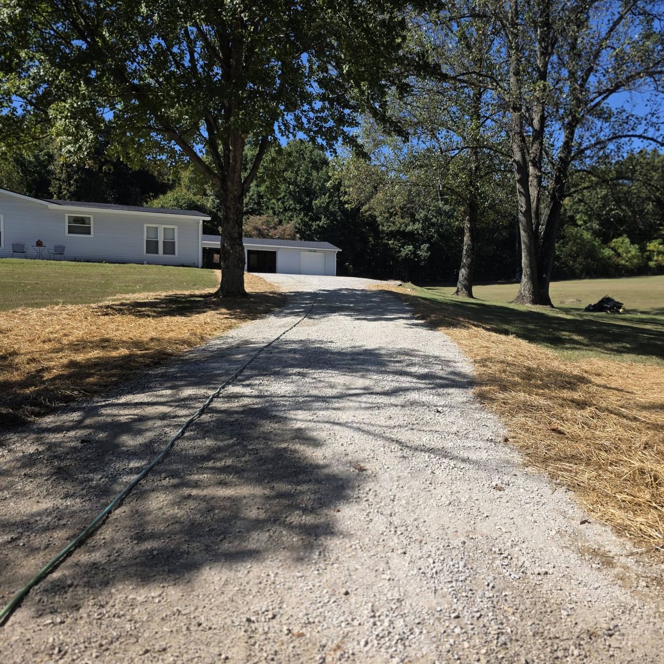 A long gravel driveway running up to a property
