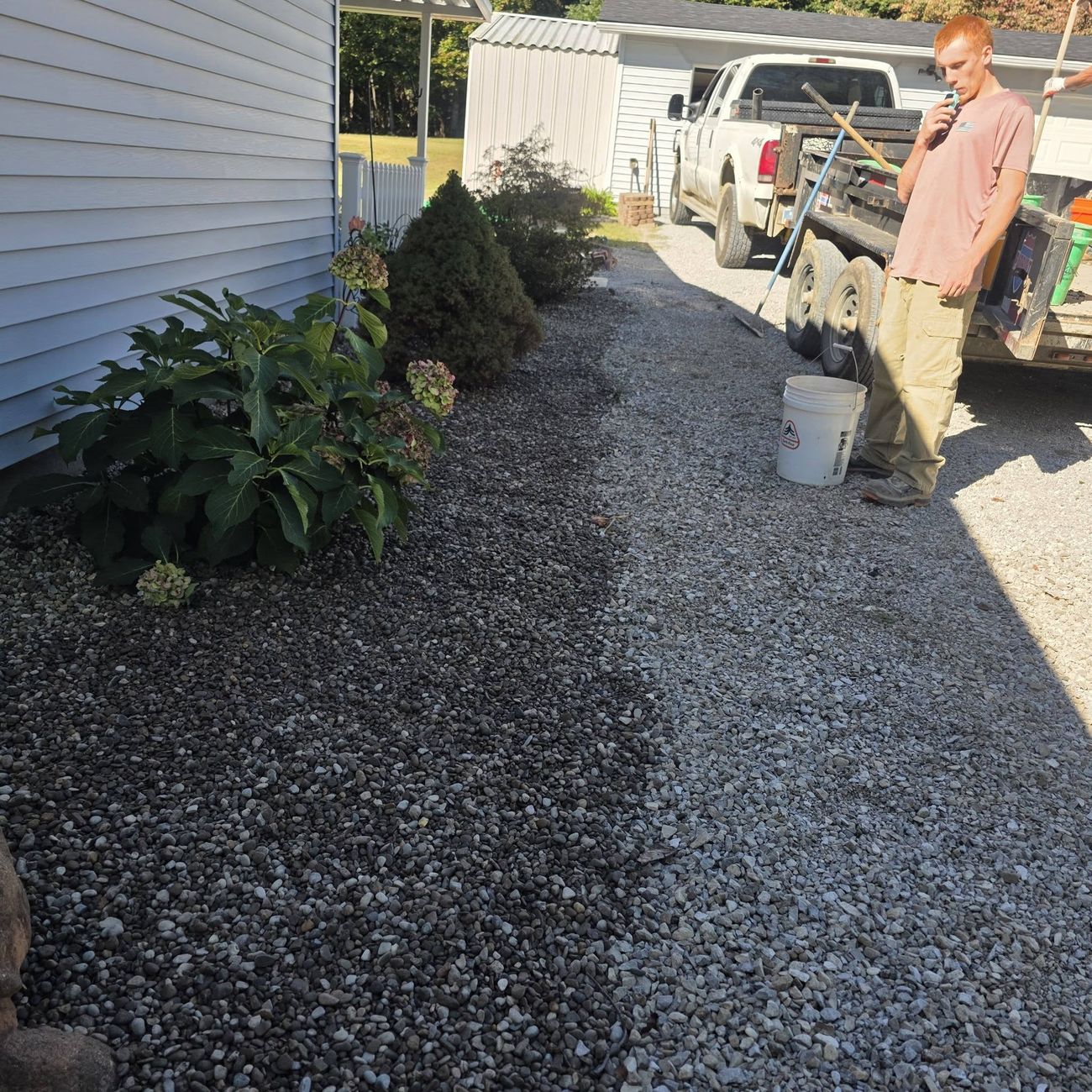 A gravel drainage path running along the side of a house